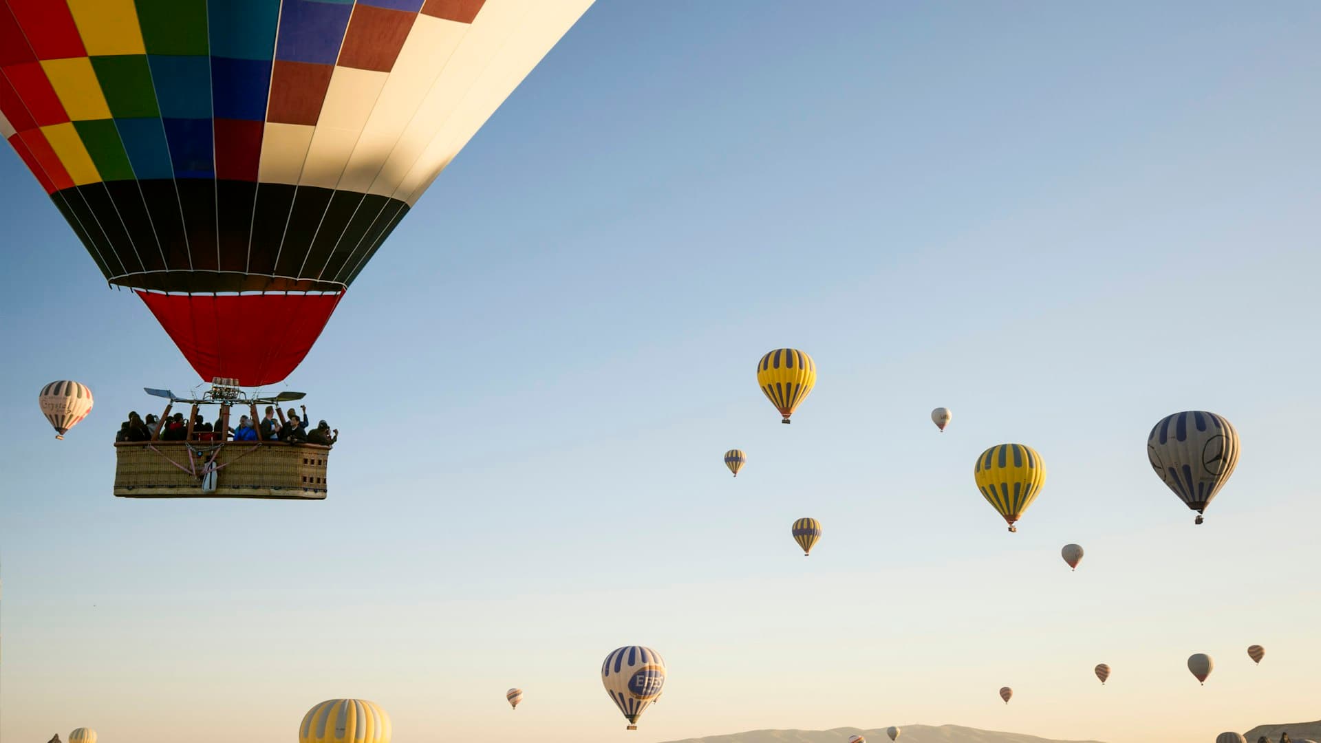 Hot air balloons floating over the fairy chimney landscape of Cappadocia at sunrise